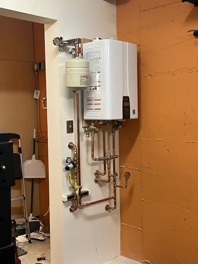 Plumbing technician inspecting water heater connections in Newark